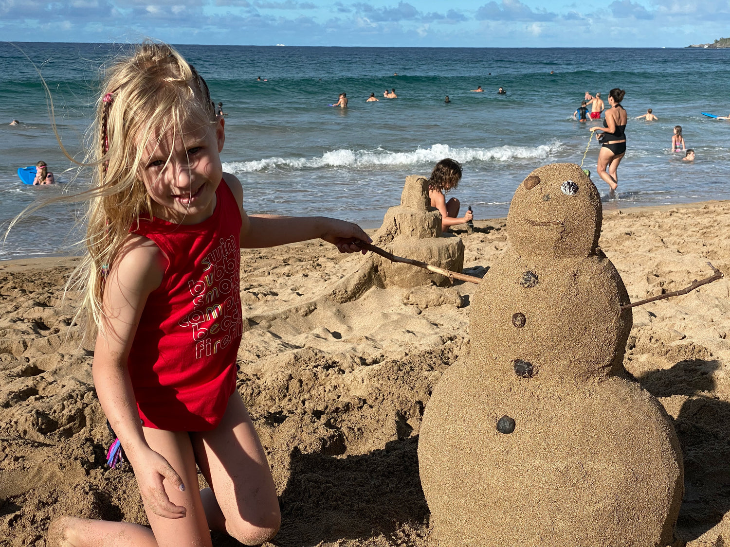 Girl joyfully building a snowman sandcastle with Pufferfish tools
