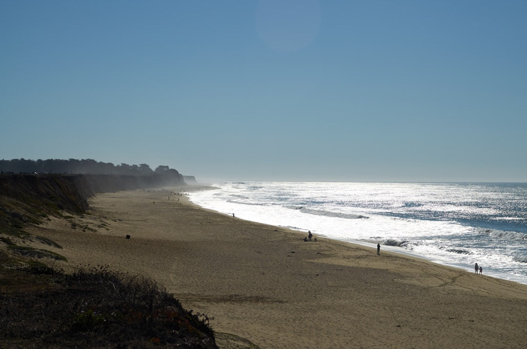 Half Moon Bay California beach - a group of people walking along a beach next to the ocean