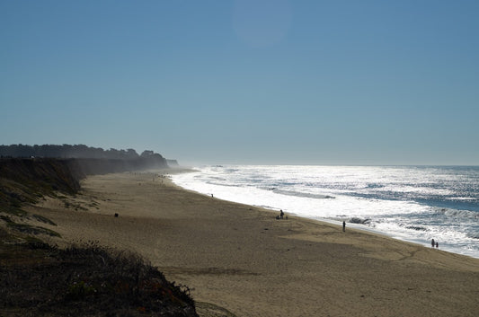 Half Moon Bay California beach - a group of people walking along a beach next to the ocean