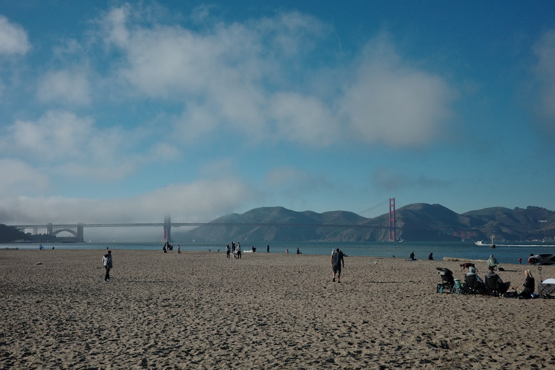 Ocean Beach San Francisco beach - Beachgoers enjoy a sunny day near the golden gate bridge.