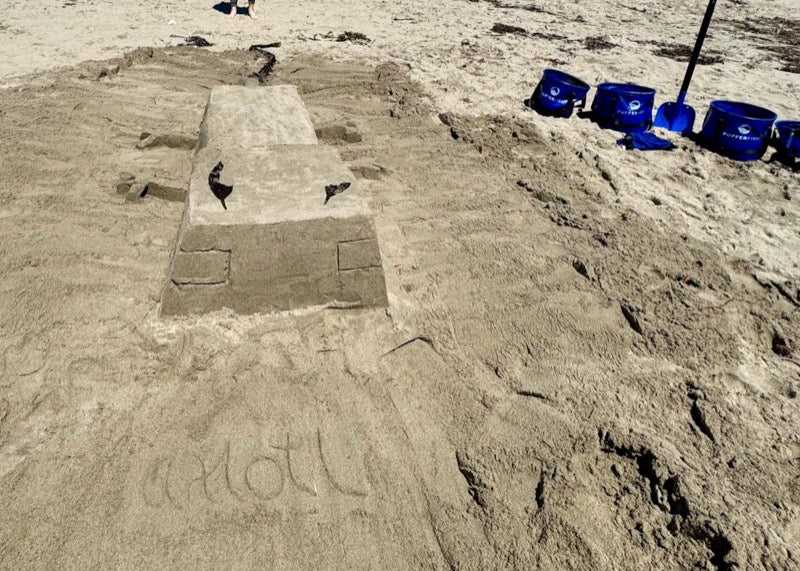 Family building sandcastle together